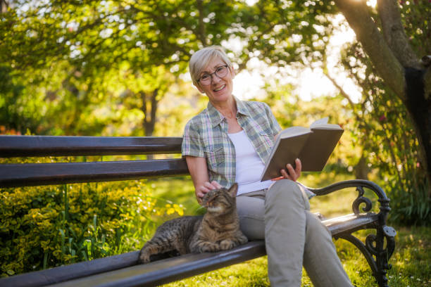 istock Senior woman reading book and spending time with her cat 2150268250