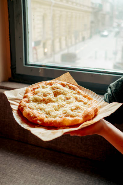 istock Woman hands holding langos - traditional Hungarian snack 2150268621