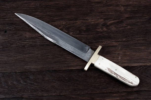 istock Old west bowie knife on wooden deck 2150270304