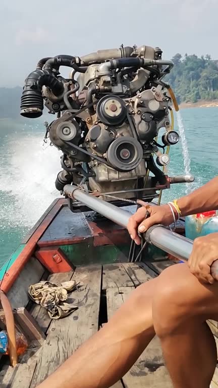 Steering and operation of the propulsion engine of a Thai longtail boat during sailing. Video with sound. Thailand.