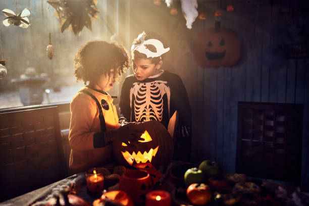 istock Shocked black siblings looking inside of Jack O' Lantern at home. 2150271342