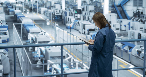 istock Thoughtful Asian Engineer Monitoring and Analyzing Conditions at a Pristine Modern Electronics Factory with Automated Robot Hands Working with the Help of Artificial Intelligence Software 2150271881