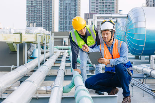 istock engineer teamwork technician workers service hotel boiler tank hot water supply pipe system. team working safety checking maintenance pipeline heating water delivery line at roof top outdoor. 2150272848