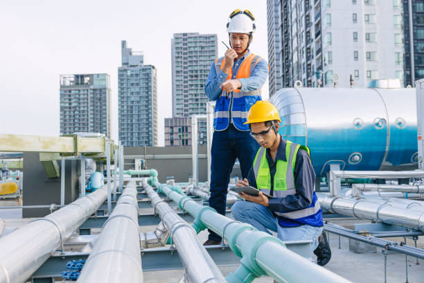istock engineer teamwork technician workers service hotel boiler tank hot water supply pipe system. team working safety checking maintenance pipeline heating water delivery line at roof top outdoor. 2150272849