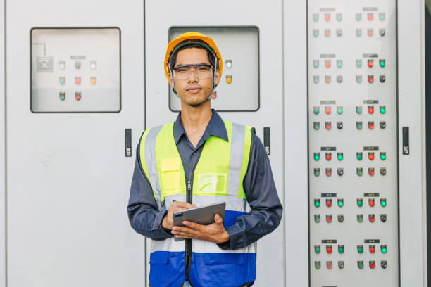 istock Asian male electrician engineer works standing at main circuit cabinet switchboard control water cooling pumping supply system. 2150272859