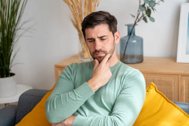 istock Pensive man sitting on couch 2150275072