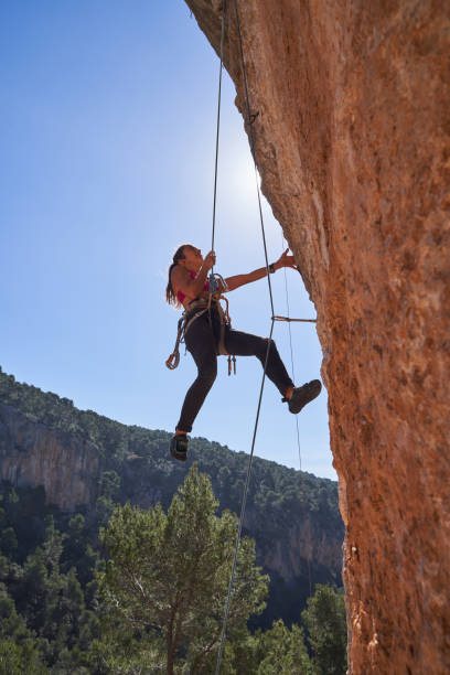 istock Female alpinist hanging from cliff on dynamic rope 2150275866