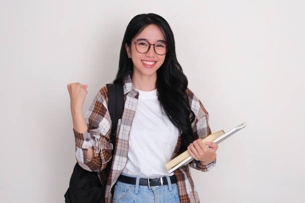istock Female college student holding books and carrying backpack showing excited expression 2150275916