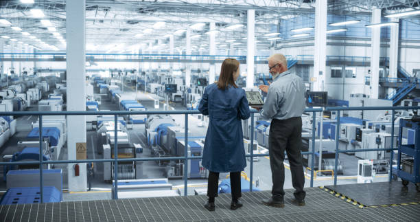 istock Middle Aged Engineer and Young Japanese Technician Having a Conversation and Using Laptop Computer. Specialists Monitoring, Analyzing Software Reports at a Modern Electronics Factory 2150276423