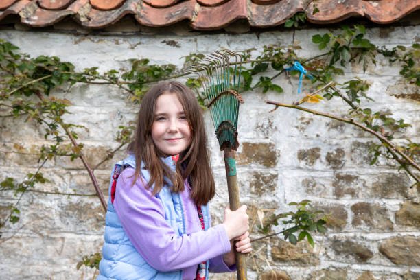 Young girl outdoors in the garden helps to prepare for the new season of growing plants