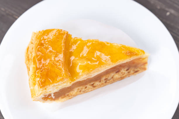 Close up of a slice of baked apple pie on a whit plate with copy space