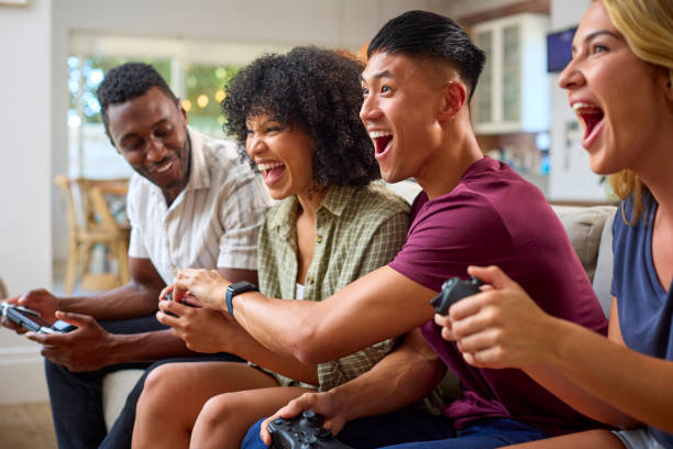 istock Group Of Excited Multi-Racial Friends Sitting On Sofa Playing Computer Games Together 2150279837