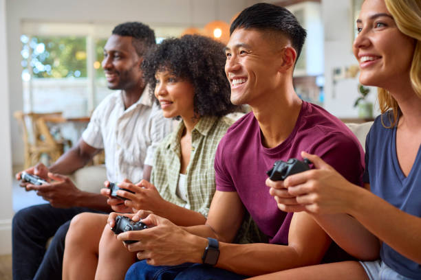 istock Group Of Excited Multi-Racial Friends Sitting On Sofa Playing Computer Games Together 2150280709