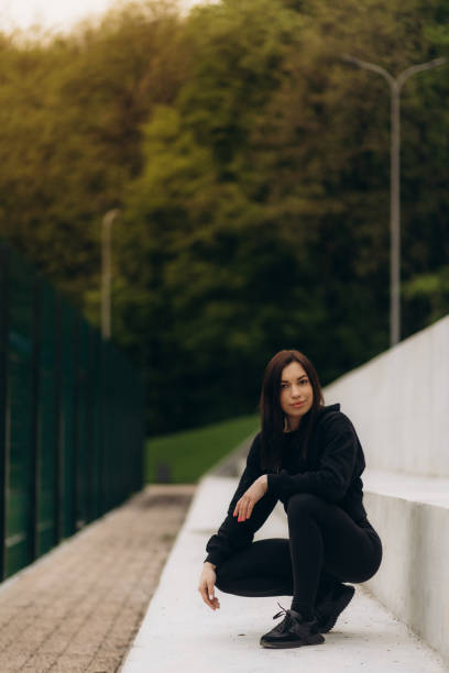 istock A fit sportswoman is stretching her legs on railing while warming up on the stairs. 2150280821