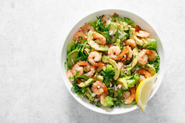 istock Shrimp avocado salad with lettuce and arugula, top view. 2150281212