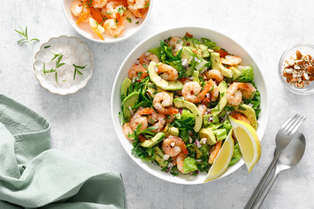 istock Shrimp avocado salad with lettuce and arugula, top view. 2150281232