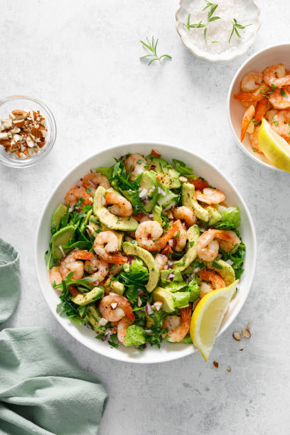Shrimp avocado salad with lettuce and arugula, top view.