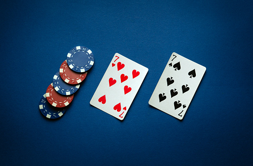 Luck in a poker game with a winning one pair combination. Playing cards and chips are laid out in a club on a blue table.
