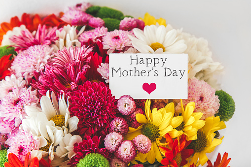 bright beautiful bouquet of multicolored flowers, white greeting card with the text Happy Mother's Day, sweet wish concept.