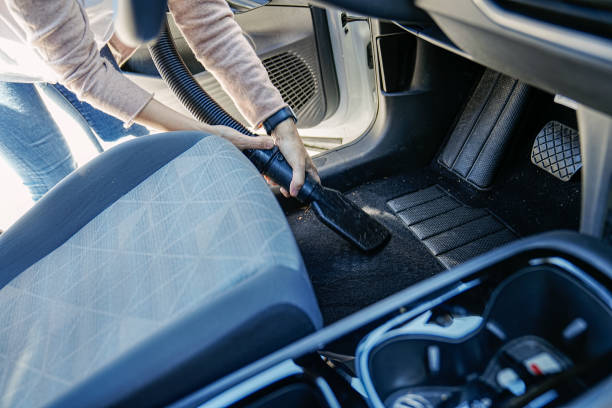 istock Efficient Cleaning Routine: Woman Vacuuming Car Floor Area 2150282213