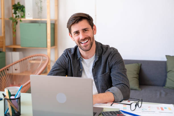 istock Smiling young professional working on laptop at modern home office 2150282918