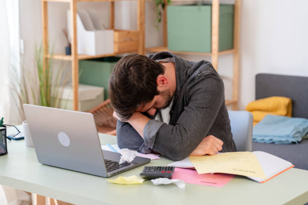 istock Overwhelmed office worker asleep at desk 2150283336