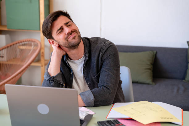 istock Man experiencing neck pain while working on laptop 2150283372