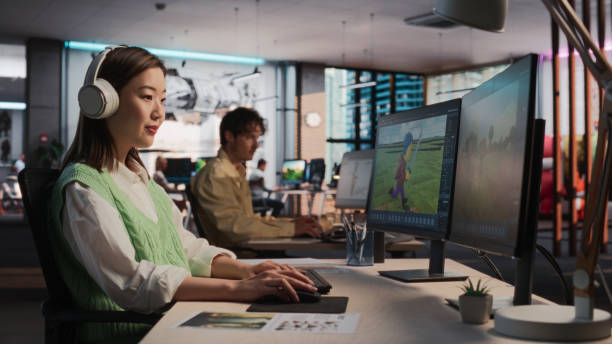 istock Female Asian Game Designer Using Desktop Computer, Designing Unique World And Characters In 3D modelling Software For RPG Video Game. Woman Working In Diverse Game Development Studio Office 2150285482