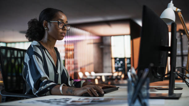 Portrait of a Beautiful Black Woman Using Desktop Computer, Analysing Data, Thinking and Solving Problems. Female Project Manager Working in Creative Agency, Reviewing Social Media Marketing Strategy