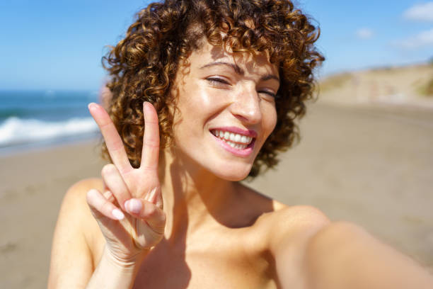 istock Happy woman showing V sign on beach 2150286942