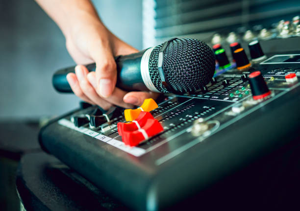 Hand Sound engineer  holding microphone on sound mixer in live broadcasting studio producer for sound record control system production and audio equipment and music instrument