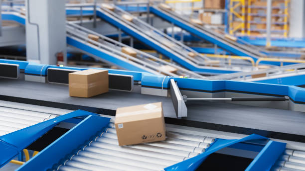 istock Automated Conveyor Belt Sorting Mechanism in a Logistics Center. Automatic Engineering Solution Handling and Preparing Parcels for Delivery to Clients. Warehouse Shot 2150292249