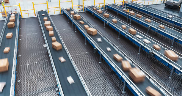 istock Establishing Shot: Modern Delivery Logistics Station Warehouse with Working Automated Conveyor Belt with Retail Parcels, Cardboard Boxes and Online Shopping Orders Being Prepared for Shipping 2150292304