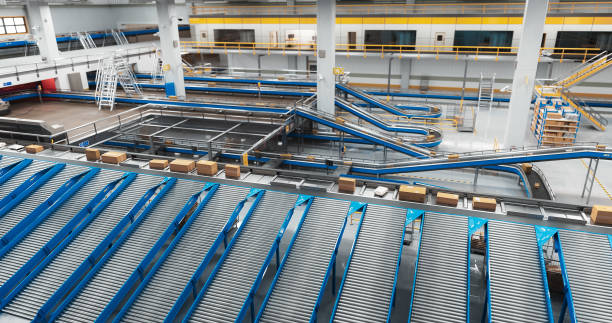 istock Establishing Shot: Modern Delivery Logistics Station Warehouse with Working Automated Conveyor Belt with Retail Parcels, Cardboard Boxes and Online Shopping Orders Being Prepared for Shipping 2150292312