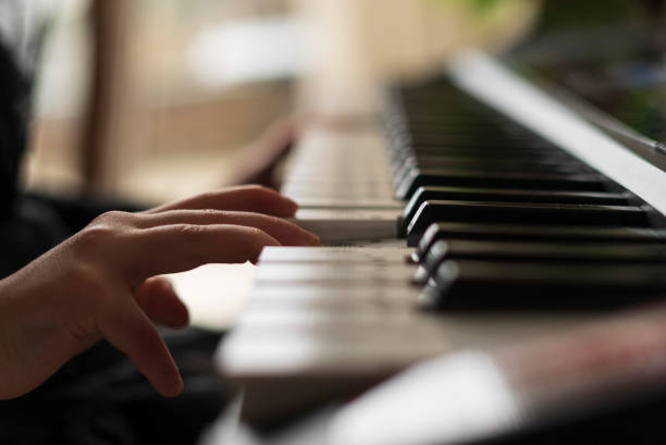 istock Close-up of a woman's hand playing on a piano. 2150292348