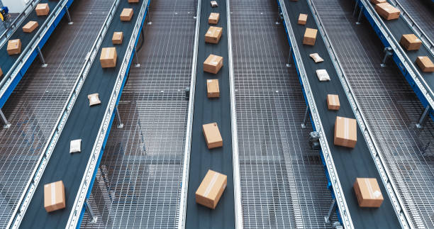 istock Modern Delivery Logistics Warehouse with Working Automated Conveyor Belt with Retail Parcels, Cardboard Boxes and Online Shopping Orders Being Prepared for Shipping 2150292414