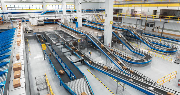istock Parcels, Cardboard Boxes and Packages Moving on a Conveyor Belt at a Modern Logistics Center with Automated Sorting Technology. 3D Graphics in Establishing Shot 2150292565