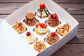 Vanilla, chocolate and peanut butter cupcakes with salted caramel, fresh raspberry, strawbeery and red currant in gift paper box