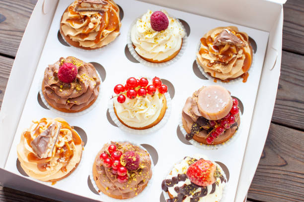istock Vanilla, chocolate and peanut butter cupcakes with salted caramel, fresh raspberry, strawbeery and red currant in gift paper box 2150295940
