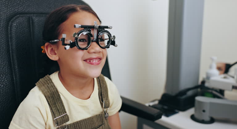 Eye exam, optometry and optician with frame for girl for testing vision, sight and glasses for child eyes. Healthcare, medical equipment and young patient with woman for prescription lens in clinic
