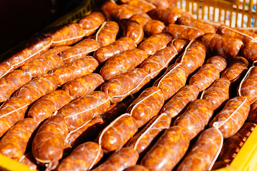 High angle crop of appetizing uncooked homemade chorizo sausages placed on table in sunlight