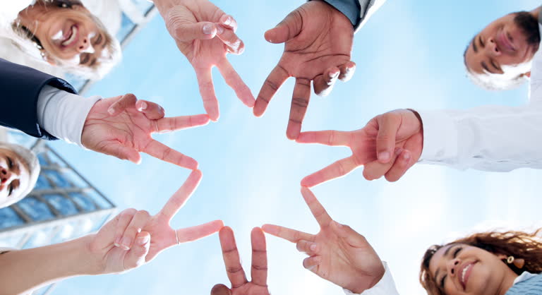 Star, low angle or business people with peace sign, hands or gesture in community collaboration with sky. Fingers, link or group of employees with teamwork support, solidarity or motivation outdoors
