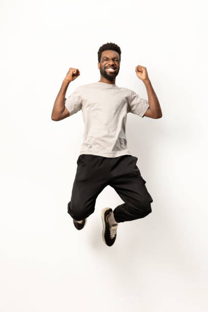 Joyful African American Man Jumping with Excitement in Studio