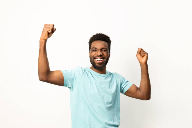 istock Joyful African American Man Celebrating Success with Arms Raised 2150299837