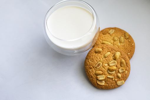 glass of milk and two cookies with nuts