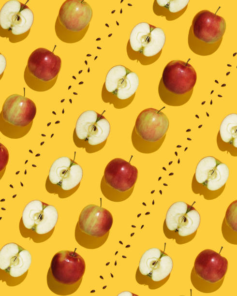 istock Fruit pattern on yellow background. Whole apples, halves and seeds in geometric order. 2150302311