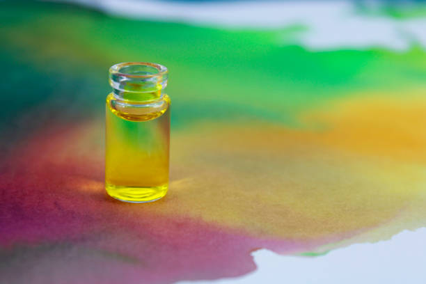A bottle of dried lavender in oil surrounded by lemon slices, lavender flowers, and herbs on a marble background. Represents aromatherapy, natural remedies, relaxation, and wellness. No people are visible.