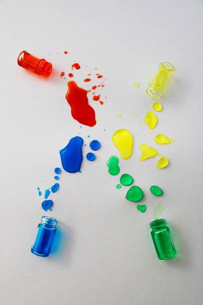 Bottles with spilled green, blue, red and yellow inks