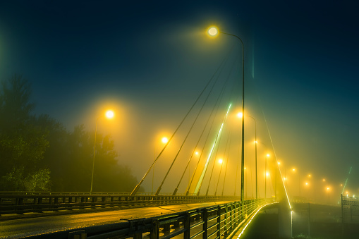 The road at night in the fog. The road leading to the bridge. Fog.