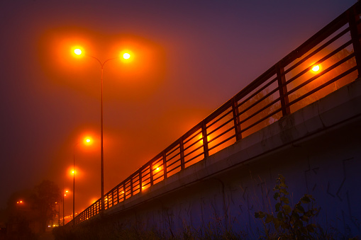 Fog. Street lighting. Arrival at the bridge in the fog.